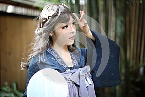 Beautiful young woman with dark blue Chinese lolita dress with Chinese garden