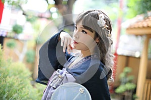 Beautiful young woman with dark blue Chinese lolita dress with Chinese garden