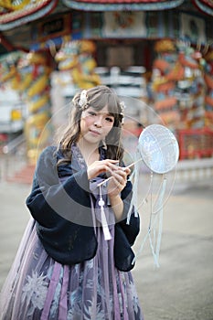 Beautiful young woman with dark blue Chinese lolita dress with Chinese garden