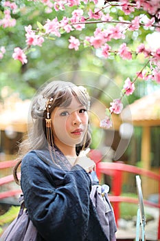 Beautiful young woman with dark blue Chinese lolita dress with Chinese garden