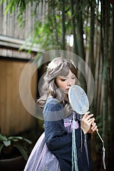 Beautiful young woman with dark blue Chinese lolita dress with Chinese garden