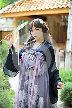 Beautiful young woman with dark blue Chinese lolita dress with Chinese garden