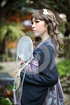 Beautiful young woman with dark blue Chinese lolita dress with Chinese garden