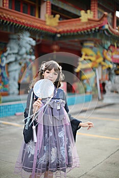 Beautiful young woman with dark blue Chinese lolita dress with Chinese garden