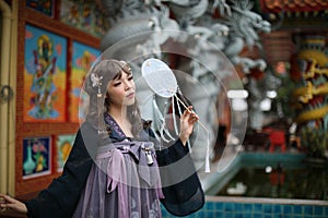 Beautiful young woman with dark blue Chinese lolita dress with Chinese garden