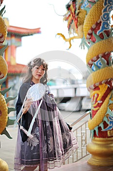 Beautiful young woman with dark blue Chinese lolita dress with Chinese garden