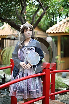 Beautiful young woman with dark blue Chinese lolita dress with Chinese garden