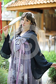 Beautiful young woman with dark blue Chinese lolita dress with Chinese garden