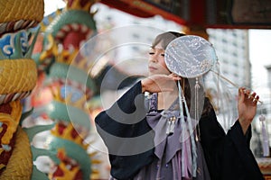 Beautiful young woman with dark blue Chinese lolita dress with Chinese garden