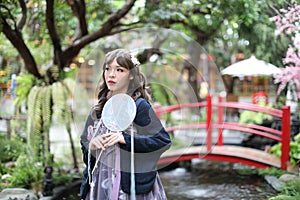 Beautiful young woman with dark blue Chinese lolita dress with Chinese garden