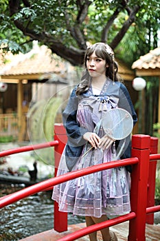 Beautiful young woman with dark blue Chinese lolita dress with Chinese garden