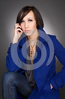 Beautiful young woman deep in thoughts. Wearing dark blue winter coat.