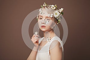 Beautiful young woman with delicate flowers in her hair