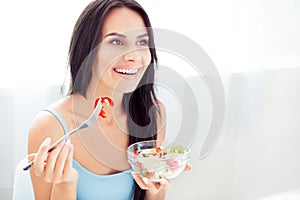 Beautiful young woman on diet eating vegetable salad