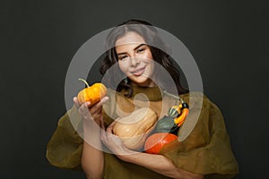 Beautiful young woman with different pumpkins. Thanksgiving or halloween portrait