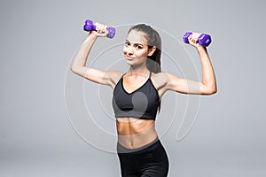 Beautiful young woman doing exercises with dumbbells at biceps. Athletic woman with perfect body isolated on white background. Str