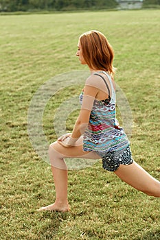 Beautiful young woman doing exercises in the park. Healthy and yoga concept. Fitness and sports
