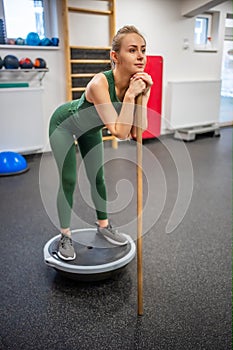 Beautiful young woman doing fitness in the gym. Girl uses fitball exercise for balance, expander, hemisphere.