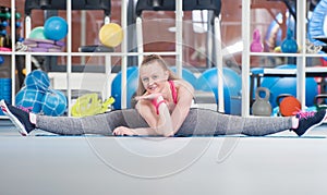 Beautiful young woman doing gimnastics on the floor