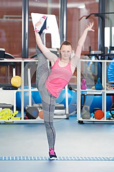 Beautiful young woman doing gimnastics on the floor