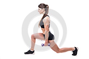 Beautiful young woman doing lunge exercise with red dumbbells in fitness gym isolated over white background