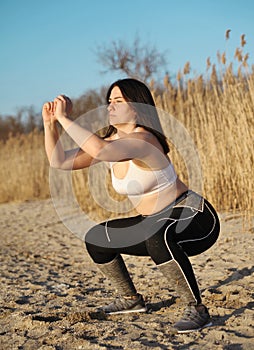 Beautiful young woman doing sports outdoors. Fitness concept.