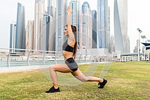 Beautiful young woman doing yoga in Dubai Skyline
