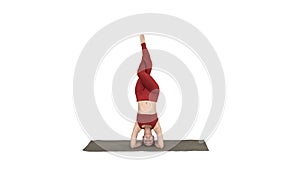 Beautiful young woman doing yoga exercise variation of supported headstand, garuda salamba sirsasana with crossed legs