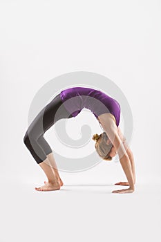 Beautiful young woman doing yoga on a white studio background