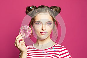 Beautiful young woman with donuts on vivid pink background
