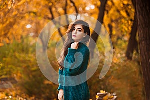 Beautiful young woman. Dramatic outdoor autumn portrait of sensual brunette female with long hair. Sad and serious girl.