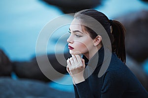 Beautiful young woman. Dramatic outdoor portrait of sensual brunette female with long hair. Sad girl in depression.