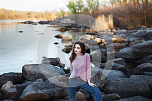 Beautiful young woman. Dramatic outdoor portrait of sensual brunette female with long hair. Sad and serious girl.