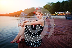 A beautiful young woman dressed sitting on the pier