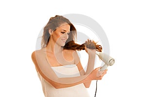 Beautiful young woman dries hair with a blow dryer
