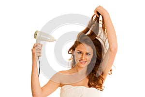 Beautiful young woman dries hair with a blow dryer