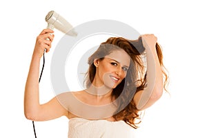 Beautiful young woman dries hair with a blow dryer