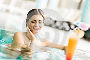 Beautiful young woman drinking a cocktail while in the swimming