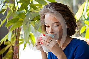 Beautiful young woman drinking coffe in a coffee shop