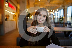 Beautiful young woman drinking coffee in a cafe restaurant