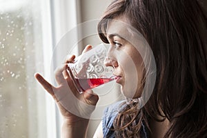Beautiful Young Woman Drinking Glass of Cranberry Juice