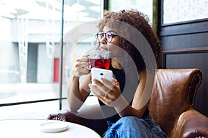 Beautiful young woman drinking red tea in a coffee shop.