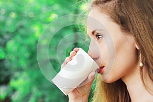 Beautiful young woman drinking takeaway coffee