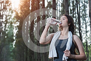 Beautiful young woman drinking water bottle after exercise fitness