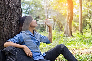 Beautiful young woman drinking water in the morning after finished jogging