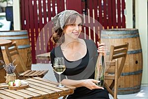 Beautiful young woman drinking white wine on the terrace of a restaurant.