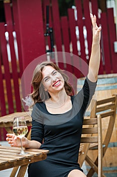 Beautiful young woman drinking white wine on the terrace of a restaurant. Relaxing after work with a glass of wine