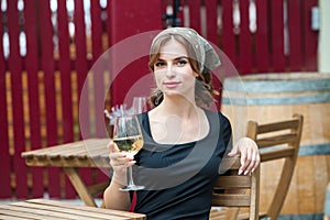 Beautiful young woman drinking white wine on the terrace of a restaurant. Relaxing after work with a glass of wine