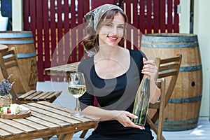 Beautiful young woman drinking white wine on the terrace of a restaurant. Relaxing after work with a glass of wine