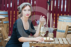 Beautiful young woman drinking white wine on the terrace of a restaurant. Relaxing after work with a glass of wine